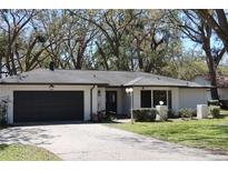 Charming single-story home with a well-manicured front lawn and an attached two-car garage at 2105 Curry Rd, Lutz, FL 33549