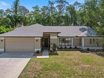 Charming one-story home with a manicured lawn, two car garage, and front landscaping at 3171 Roxmere Dr, Palm Harbor, FL 34685