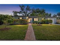 Charming single-story home with well-manicured lawn, walkway, and mature trees under a lovely dusk sky at 3614 S Lois Ave, Tampa, FL 33629