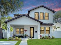 Charming two-story home with white stucco, dark trim, manicured lawn, and inviting covered front porch at 4015 10Th N Ave, St Petersburg, FL 33713