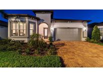 Charming single-Gathering home with a two-car garage, beautiful landscaping, and brick driveway at 5858 Shorebird Br, Land O Lakes, FL 34638