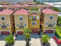 Charming townhomes with red tile roofs, private garages, and lush palm tree landscaping at 6407 Mayra Shores Ln, Apollo Beach, FL 33572