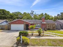Charming single-story home with a well-manicured lawn, stone accents, and an attached garage at 11467 93Rd St, Largo, FL 33773