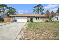 Charming single-story home featuring stone accents, attached garage, and a concrete driveway at 1371 Meredith Dr, Spring Hill, FL 34608