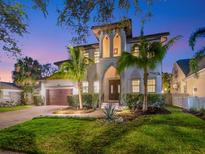 Elegant two-story home featuring lush landscaping, a spacious driveway, and exquisite architectural details at 150 Chippewa Ave, Tampa, FL 33606