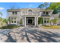 Stately two-story home featuring a beautiful double-door entrance, a large porch, and manicured landscaping at 15702 Richboro Ct, Tampa, FL 33647