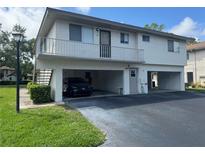 Two-story condo building featuring covered parking and a balcony on the second floor at 1830 Bough Ave # 4, Clearwater, FL 33760