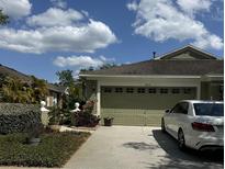 Charming single-Gathering home featuring a spacious two-car garage, well maintained landscaping, and a paved driveway at 19113 Doves Landing Dr, Tampa, FL 33647