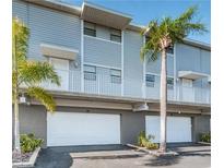 Modern condo with two stories, a garage, and landscaping with palm trees create a coastal charm at 19823 Gulf Blvd # 42, Indian Shores, FL 33785