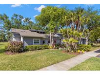 Charming home featuring lush landscaping and mature trees in a tranquil setting at 20 Iris Pl, Oldsmar, FL 34677