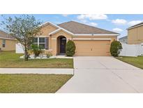 Charming one-story home with a two-car garage, inviting entryway, and well-manicured lawn at 36734 Goffaux Loop, Zephyrhills, FL 33541