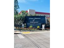 Attractive Town Shores of Gulfport sign with flower beds and mature tropical landscaping at 6020 Shore S Blvd # 903, Gulfport, FL 33707