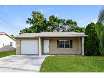 Charming single-story home with a well-maintained lawn and a one car garage at 7338 Coventry Dr, Port Richey, FL 34668