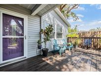 Charming front porch with seating, mature plants, and a decorative front door at 201 11Th S Ave, Safety Harbor, FL 34695