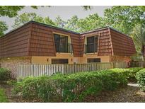 Charming townhome with brick and siding exterior, featuring a unique roofline and mature landscaping at 2725 14Th Ct, Palm Harbor, FL 34684