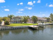 Waterfront home with dock, boat lift, and lush landscaping offers prime coastal living on a sunny day at 3901 Pompano Se Dr, St Petersburg, FL 33705
