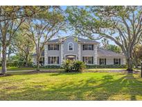 Beautiful two-story home with a symmetrical facade, dark shutters, and a well-manicured front lawn at 4121 Highland Park Cir, Lutz, FL 33558
