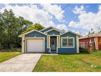 Charming single-Gathering home featuring blue and beige exterior with a well-maintained lawn and attached garage at 4610 Courtland St, Tampa, FL 33610