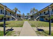 A well-maintained courtyard featuring lush green grass, palm trees, and a central walkway at 525 9Th N Ave # 2, St Petersburg, FL 33701
