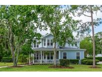 Charming two-story home with inviting front porch and beautifully landscaped front yard at 5913 Flatwoods Manor Cir, Lithia, FL 33547
