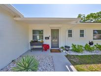 Inviting front entrance with decorative landscaping and a freshly painted exterior, and neutral colors at 7491 Cedar Ne St, St Petersburg, FL 33702
