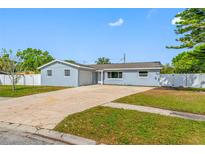 Charming single-story home with a well-maintained lawn and a long driveway at 8409 Lantana Dr, Seminole, FL 33777