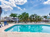 Outdoor brick pool with refreshing water and poolside chairs, perfect for relaxing and enjoying the beautiful waterfront scenery at 8722 Hickorywood Ln, Tampa, FL 33615