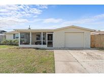 Charming single-story home features a stone facade, screened porch, and attached garage at 3748 Redwood Dr, Holiday, FL 34691