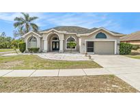 Charming single-story home with arched entry, well-maintained landscaping, and a two-car garage at 13403 Bolton Ct, Spring Hill, FL 34609