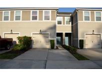 Inviting townhome featuring a well-maintained exterior, attached garages, and a charming entrance with landscaped accents at 17833 Althea Blue Pl, Lutz, FL 33558