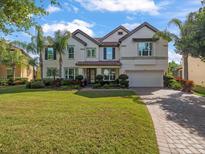 Beautiful two-story home with a well-manicured lawn and mature landscaping and a tile roof at 1804 Bella Casa Ct, Tampa, FL 33618