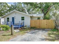 Inviting home exterior with a blue porch, complemented by mature trees and a freshly stained, wooden fence at 1920 30Th E Ave, Bradenton, FL 34208