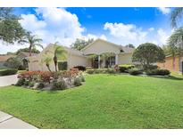 Charming single-story home featuring lush landscaping, a well-manicured lawn, and a welcoming entrance at 2605 Durant Trails Blvd, Dover, FL 33527
