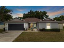 Charming single-story home with well-manicured lawn, gray exterior, and a sleek, dark gray garage door at 3011 49Th S Ter, St Petersburg, FL 33712