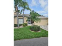Inviting one-story home with lush landscaping and a well-manicured lawn at 607 Manchester Woods Dr # 84, Sun City Center, FL 33573