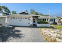 Charming single-story home featuring a spacious two-car garage and tidy landscaping, set under a clear blue sky at 7136 Isle Dr, Port Richey, FL 34668
