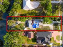 An aerial view of the property showcases its waterfront location and surrounding lush landscape at 8615 Jackson Springs Rd, Tampa, FL 33615