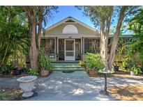 Charming home with lush landscaping, a screened porch, and a inviting entryway at 921 24Th N Ave, St Petersburg, FL 33704