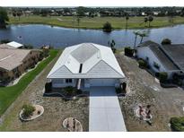 Beautiful aerial view of the home with a lake view and well-manicured landscaping at 1806 Wolf Laurel Dr, Sun City Center, FL 33573