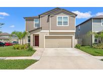 Charming two-story home with a two-car garage, landscaped yard, and inviting curb appeal at 22359 Storybook Cabin Way, Land O Lakes, FL 34637