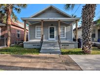 Charming single-story home featuring a quaint front porch and manicured landscaping at 2317 W Chestnut St, Tampa, FL 33607