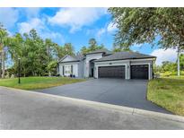 Charming single-story home with a well-manicured lawn and a three-car garage at 2332 Dekan Ln, Land O Lakes, FL 34639