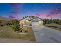 Charming single-story home with well-manicured lawn, decorative driveway, and two-car garage at 334 Northway Dr, Sun City Center, FL 33573
