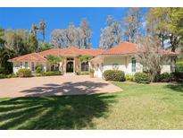 Stunning single story home with a red tile roof, paver driveway, lush landscaping, and a circular driveway at 3607 Berger Rd, Lutz, FL 33548
