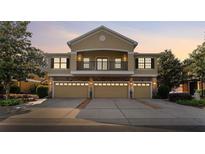 A home exterior with a stone-clad facade, balcony, three garages, and a well-kept driveway at 5717 Kingletsound Pl, Lithia, FL 33547