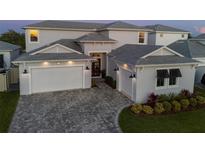 Stunning two-story home with three-car garage, beautiful landscaping, and a paver driveway at 8720 Drummer Plank Dr, Wesley Chapel, FL 33545
