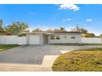 Charming single-story home featuring a well-maintained yard and attached garage at 8801 Sunlit Cove Ne Dr, St Petersburg, FL 33702