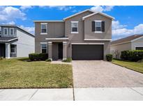 Charming two-story home with a well-manicured lawn, two-car garage, and a welcoming front porch at 13802 Kinsale St, Riverview, FL 33579