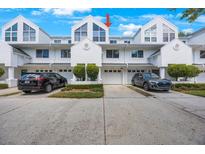Attractive townhome exterior with a one car garage, manicured landscaping, and a clean driveway at 14649 Seminole Trl # 5, Seminole, FL 33776