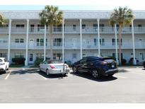 Three-story condo with white facade and palm trees in the parking lot at 2449 Columbia Dr # 53, Clearwater, FL 33763